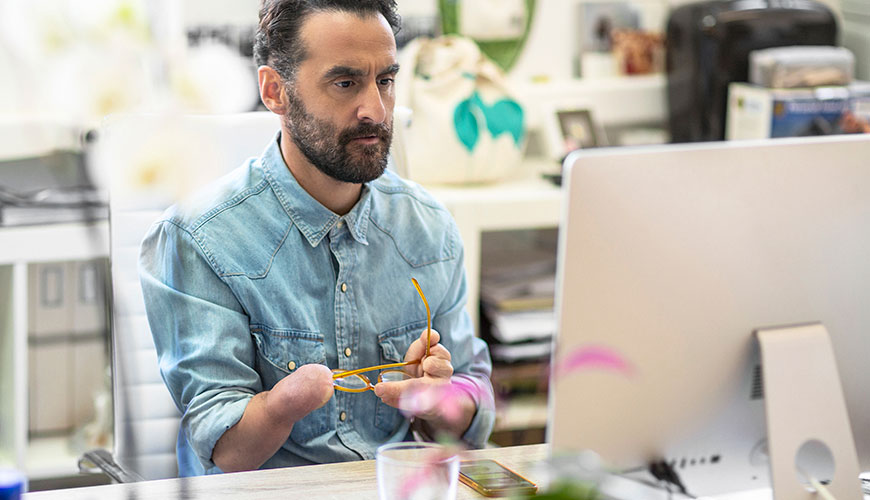 A person with a disability sits working at a laptop