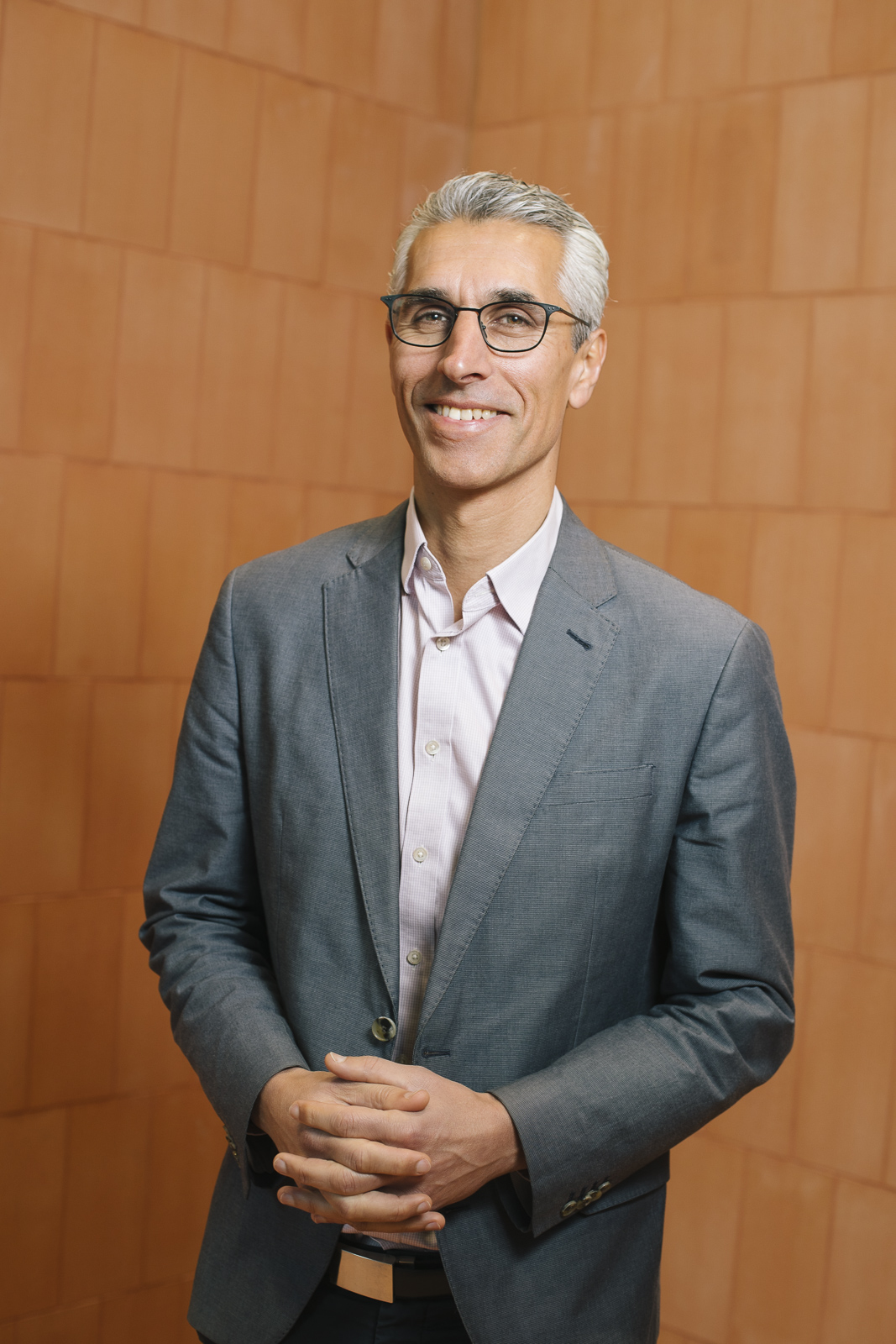 Human Rights Commission President, Hugh de Kretser. Smiling, middle aged man in grey suit with white hair and glasses