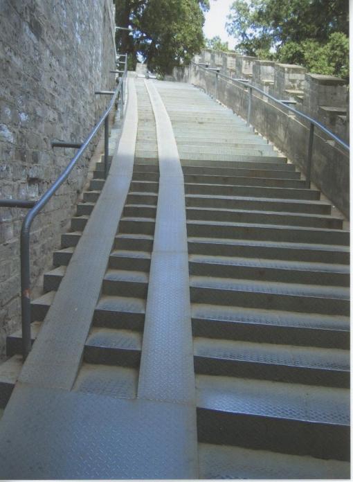 Steel ramp overlaid up one side of long staircase, possible gradient 1 in 3