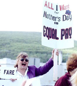 Image: Woman protester with sign that reads "All I want for Mother's Day is Equal Pay!" Photograph by Shannon de Celle