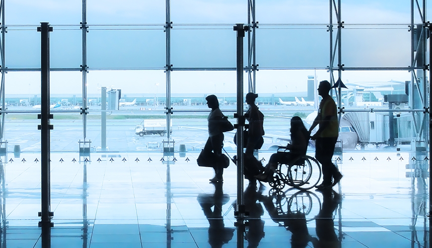 family including person using a wheelchair walking through an airport