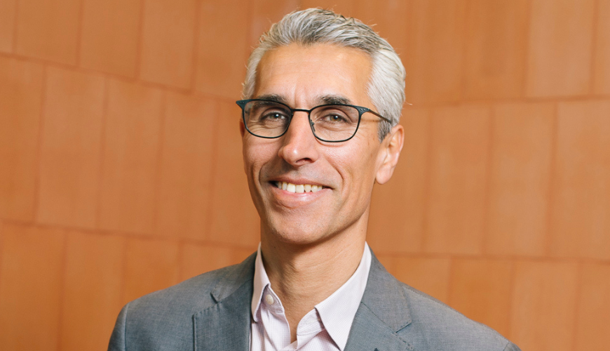 Human Rights Commission President, Hugh de Kretser. Smiling, middle aged man in grey suit with white hair and glasses