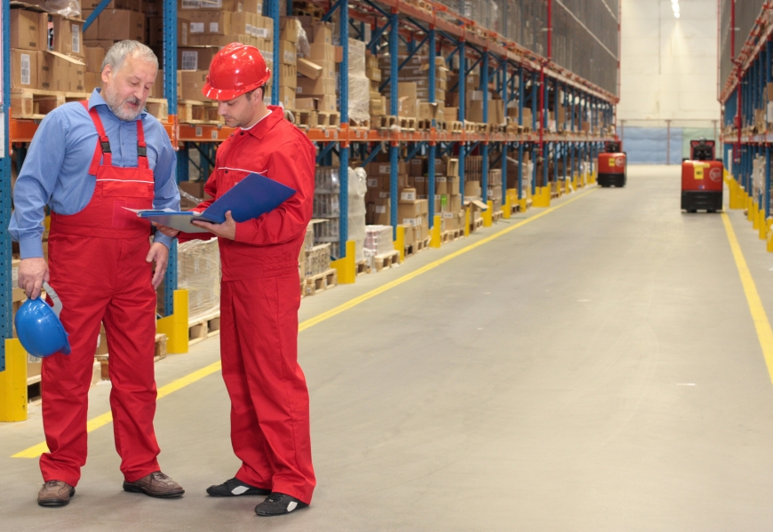 Multi generational workers reading invoice in warehouse