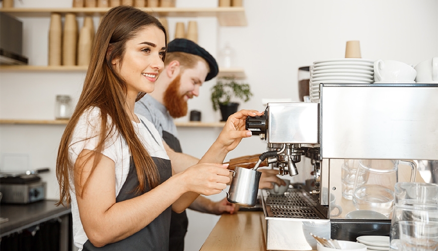 Female and male baristas in cafe