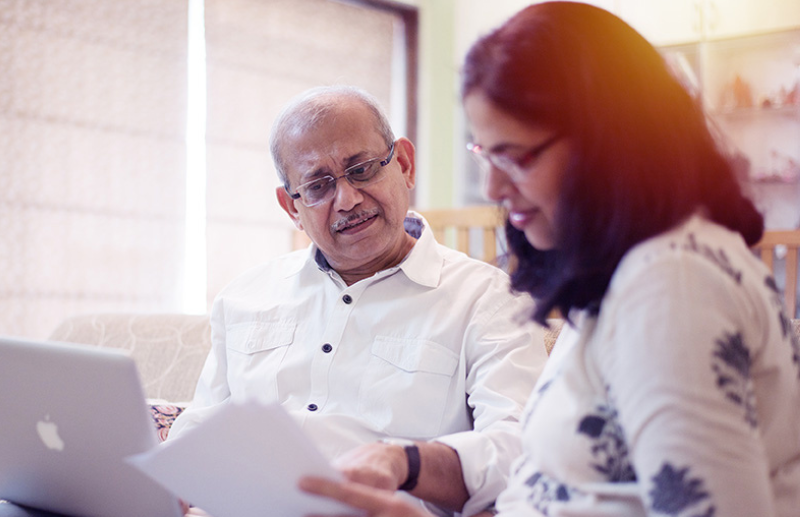 older man looks over documents with adult daughter