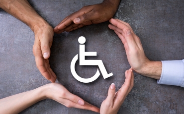 people's hands encircling a disability icon