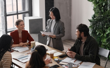 High angle portrait of diverse group of business people meeting at table in modern office interior decorated by plants