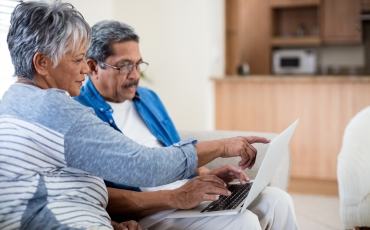 Senior couple look at laptop