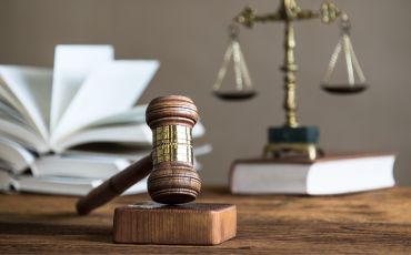 judge's gavel with legal scales and law book