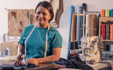 Beautiful woman working in the tailoring industry poses in front of the camera for a portrait.