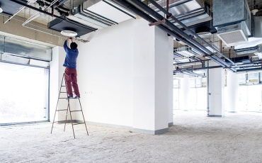 Worker up a ladder in building being refitted