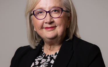 headshot of woman wearinhg glasses and black jacket