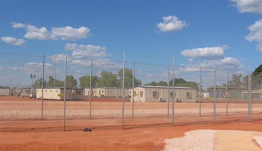 Immigration detention centre in dusty field