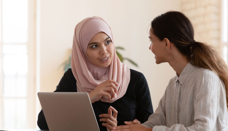 Multicultural businesswomen brainstorm cooperating at office meeting.