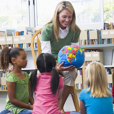 teacher showing globe to class