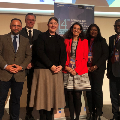 Six people, including Human Rights Commissioner Lorraine Finlay, standing in a conference room in front of a projector screen.