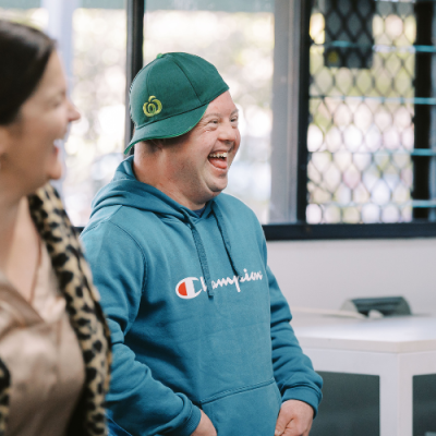 A woman and a man smiling and laughing together.